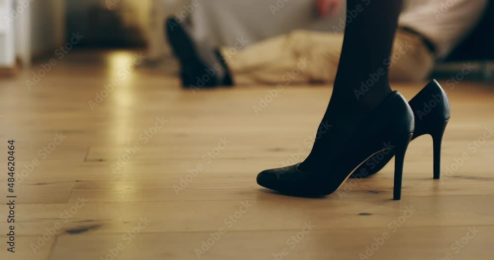 The kind of sex great fantasies are made of. Closeup of woman wearing high heels in the bedroom with husband in the background. Sexy, romantic moment of couple in love at home The kind of sex great fantasies are made of. Closeup of woman wearing high heels in the bedroom with husband in the background. Sexy, romantic moment of couple in love at home