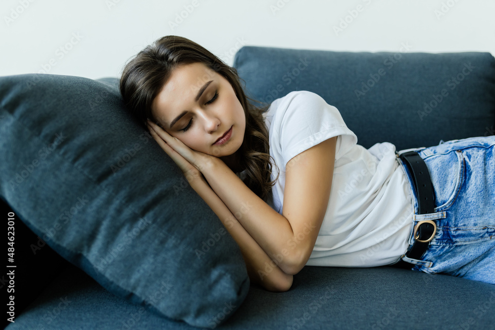 Young woman lying on comfy couch sleeping or having day nap resting alone Young woman lying on comfy couch sleeping or having day nap resting alone