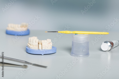 Close-up of tools for painting work on artificial dentition and dental imprint in a dental laboratory on a workbench