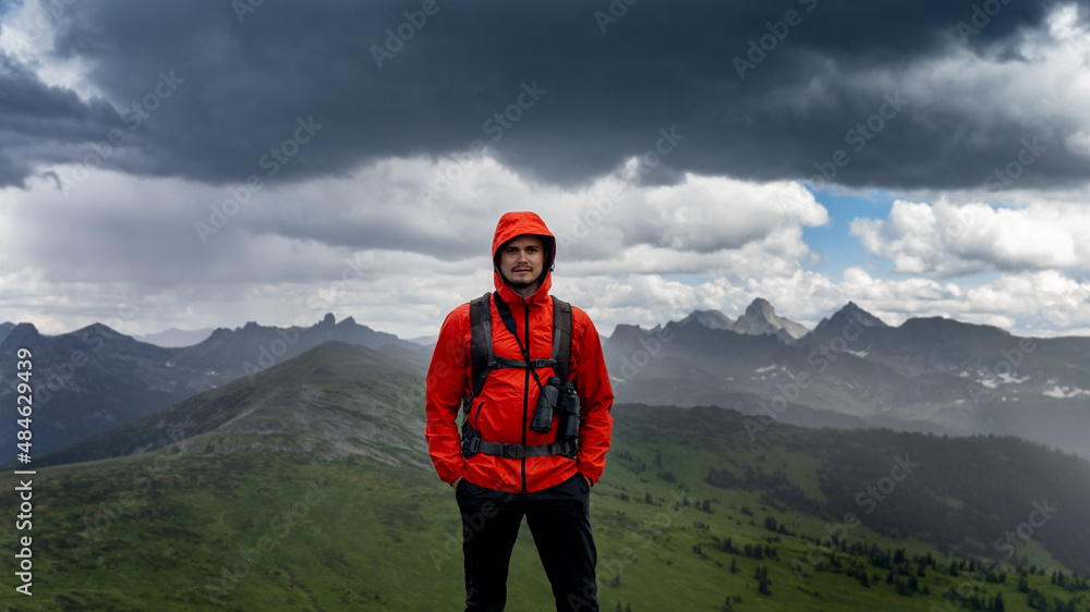 portrait of an adventure man with binoculars and explorer extreme equipment on the mountain. Lifestyle wandering adventure. summer vacation outdoors.