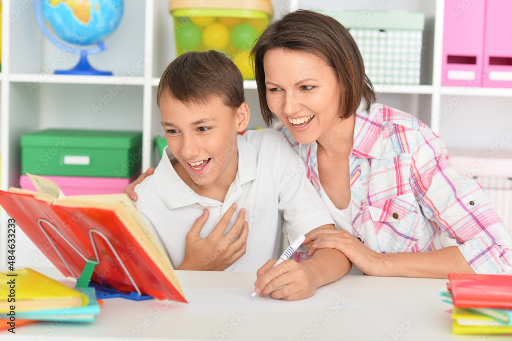 Porait of surprised mother with her son doing homework at home Porait of surprised mother with her son doing homework at home