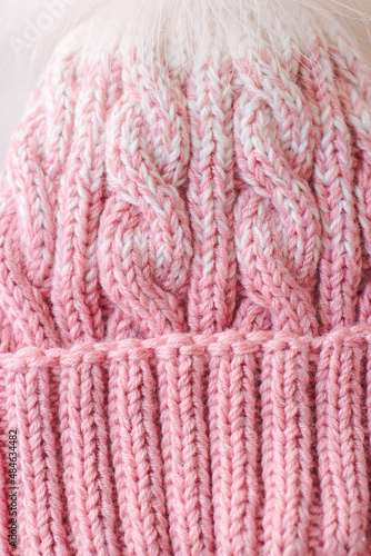 Pink knitted beanie on a white background