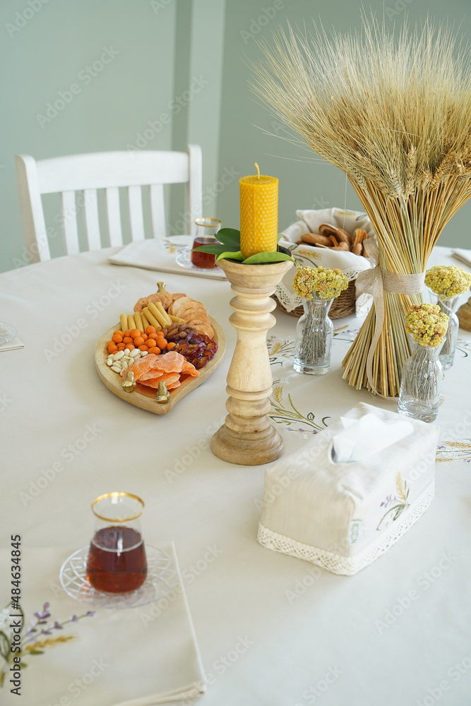 Table with orange cookies, fruits snacks.