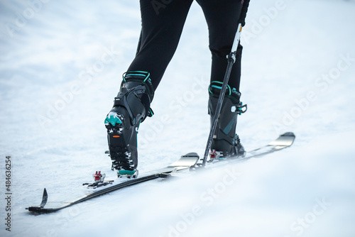 Mountaineer ski walking on the snow going up to the mountain. Adventure winter sport.
