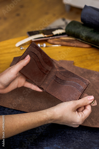 Brown wallet  made of genuine leather on a leather background