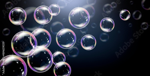 Realistic soap bubbles with rainbow reflection on black backgraund