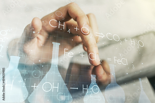 Creative chemistry illustration with finger presses on a digital tablet on background, science and research concept. Multiexposure