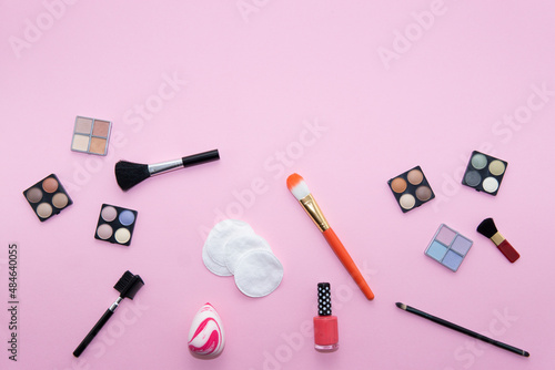 Make-up items, brush, cotton, nail polish on pink background. Beauty concept