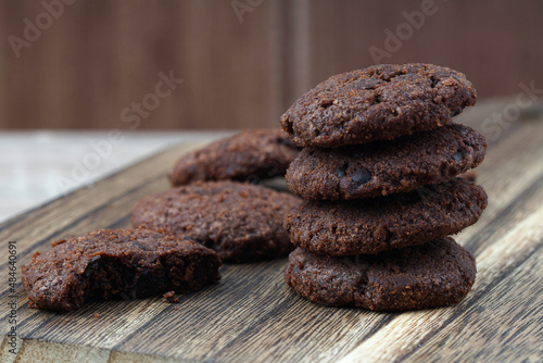 Close up stack of dark chocolate cookies on a chopping board