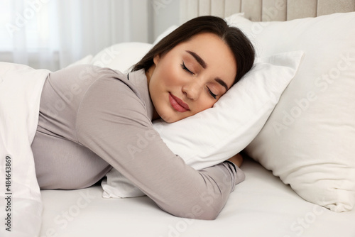 Beautiful young woman sleeping in bed at home