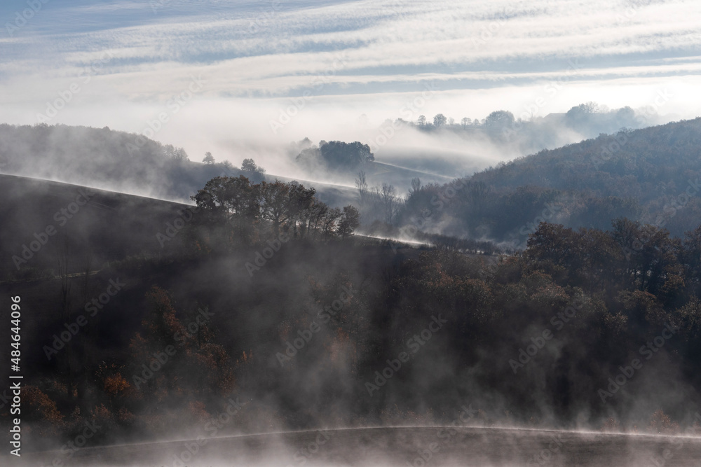 Brume fumante et nappe de nuage au lever du soleil en hiver dans le forêts et les collines du Gers