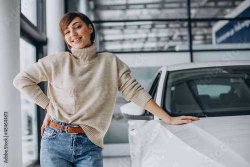 Woman in a car showroom choosing a new car