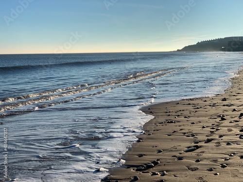 Portrait of small waves covering a sandy beach