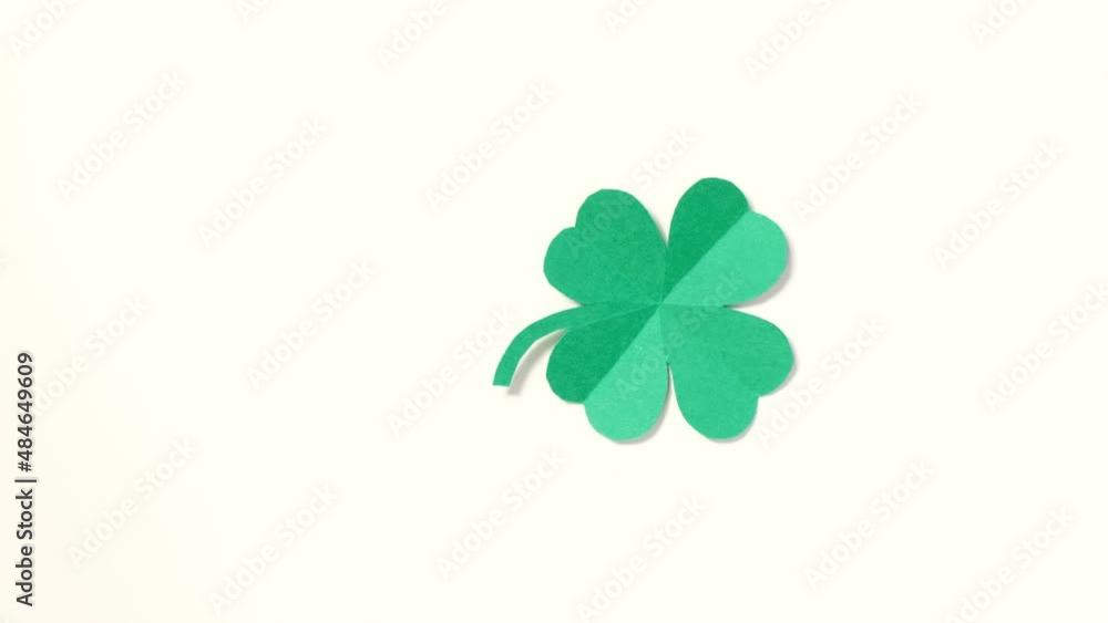 St. Patrick's Day. A leaf of clover cut out of paper is spinning on a white background. High quality 4k footage. vertical video St. Patrick's Day. A leaf of clover cut out of paper is spinning on a white background. High quality 4k footage. vertical video