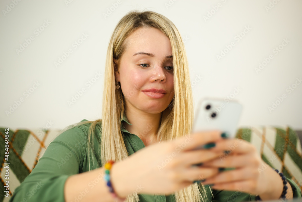 Domestic violence victim with facial scar and prosthetic eye typing message on modern mobile phone with cheerful smile. Abuse survivor woman living happy life Domestic violence victim with facial scar and prosthetic eye typing message on modern mobile phone with cheerful smile. Abuse survivor woman living happy life