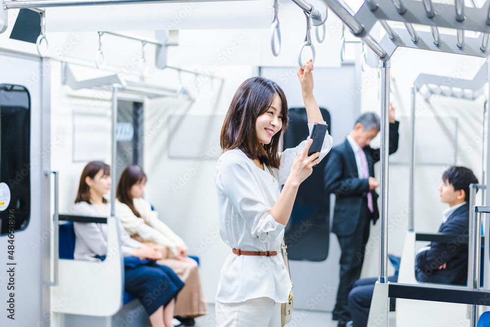 電車でスマホを使う若い女性 電車でスマホを使う若い女性