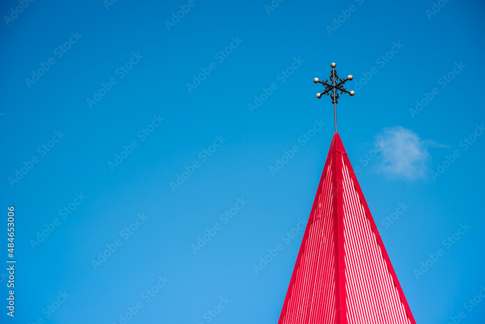 Abstract image with a red spire of a Christian church.