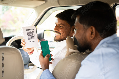 Obraz na plátně Foucs on cab driver passanger paying to taxi driver by scanning bar code after ride - conept of online secure payment, banking technology and financial in transportation