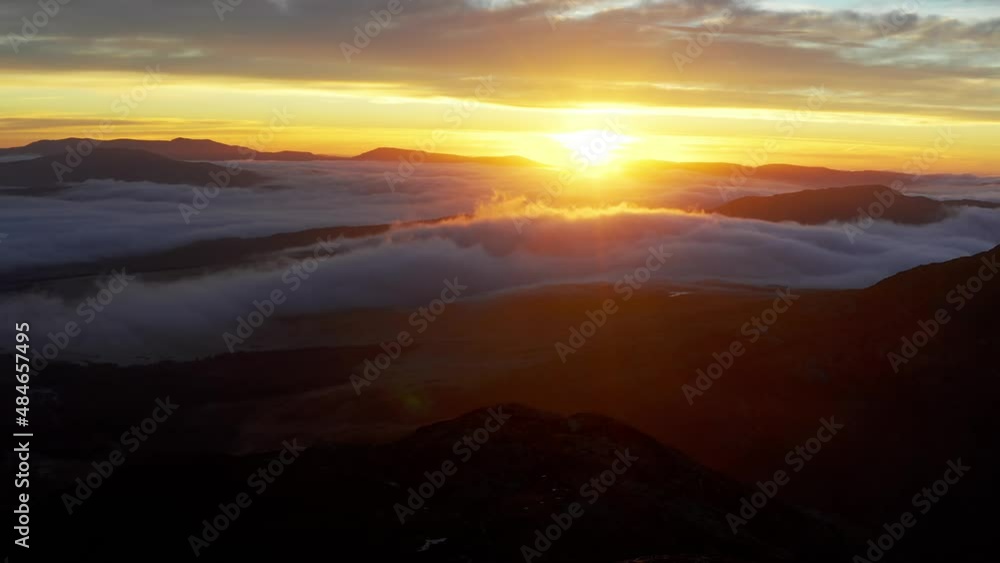 Mountain aerial sunrise with low cloud and deep red shadows Mountain aerial sunrise with low cloud and deep red shadows