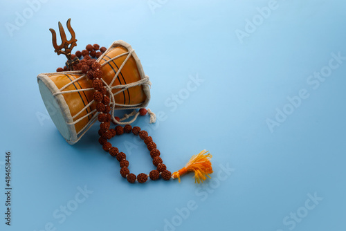 Fototapeta Shivaratri background with Shivas trident and Pellet Drum Damroo musical instrument