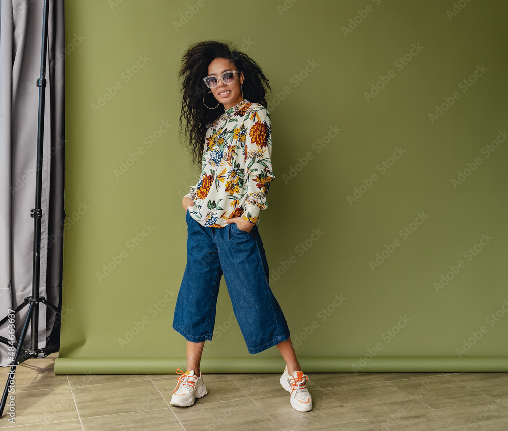 attractive black african american woman in stylish outfit on green studio background attractive black african american woman in stylish outfit on green studio background