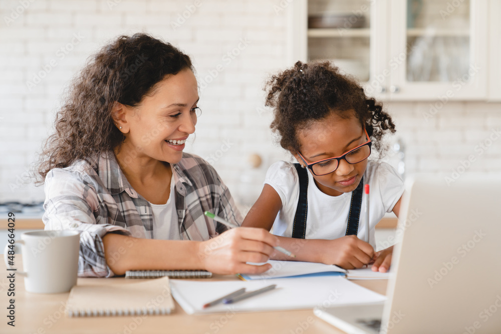 Tutoring homeschooling concept. African mother mom nanny childminder helping daughter with homework, drawing together, e-learning, preparing for school art project at home. Tutoring homeschooling concept. African mother mom nanny childminder helping daughter with homework, drawing together, e-learning, preparing for school art project at home.