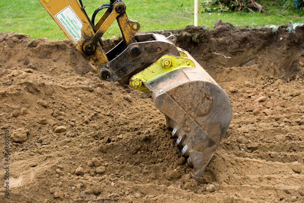 Excavator digging soil. Close up view of excavator shovel. Excavator digging soil. Close up view of excavator shovel.