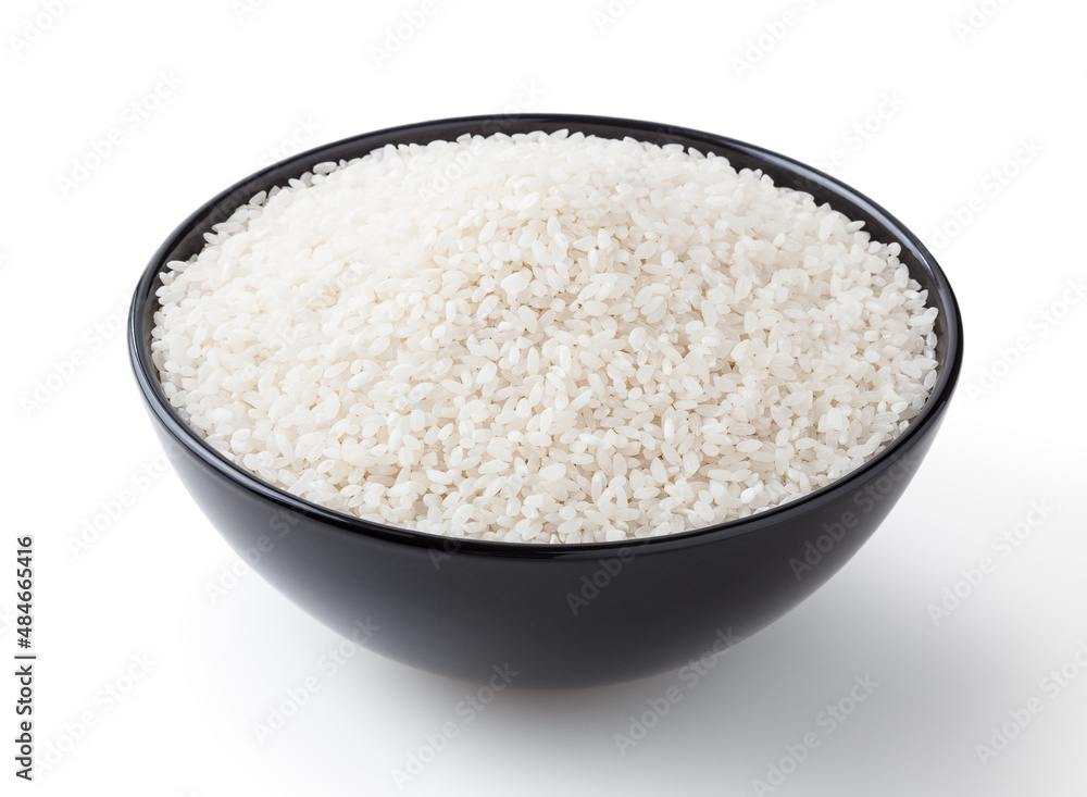 Uncooked round rice in black bowl isolated on white background with clipping path Uncooked round rice in black bowl isolated on white background with clipping path