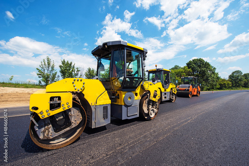 Obraz na płótnie industrial landscape with rollers that rolls a new asphalt in the roadway. Repair, complicated transport movement. w salonie