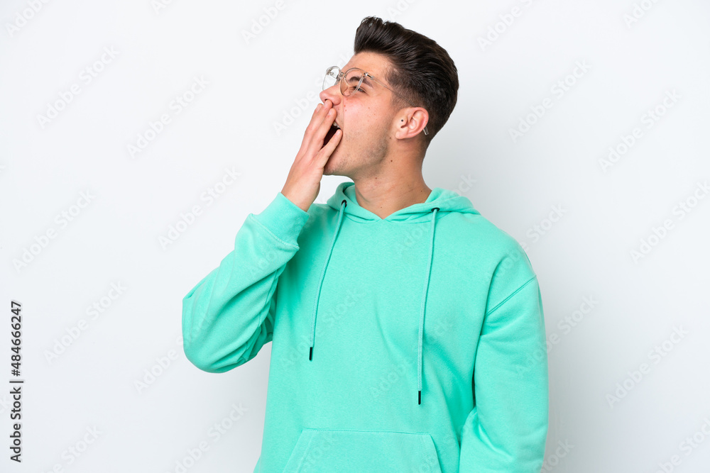 Young handsome caucasian man isolated on white bakcground yawning and covering wide open mouth with hand Young handsome caucasian man isolated on white bakcground yawning and covering wide open mouth with hand