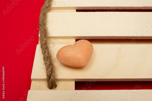 Heart-shaped soap on wooden palette as tray on red background. Love valentine concept