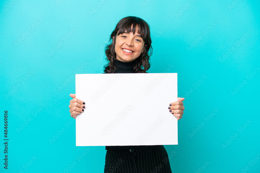 Young latin woman isolated on blue background holding an empty placard with happy expression Young latin woman isolated on blue background holding an empty placard with happy expression