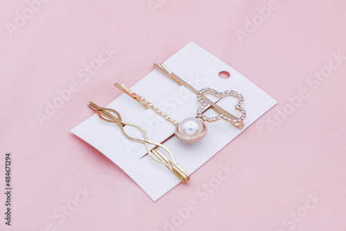 Luxury hair clips on pink background.