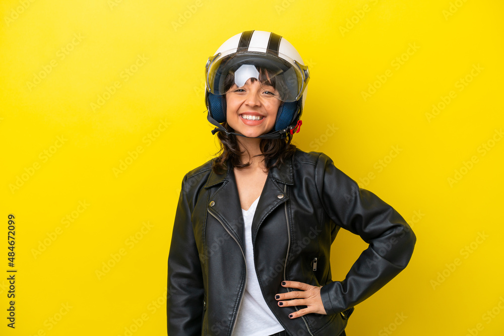 Young latin woman with a motorcycle helmet isolated on yellow background Young latin woman with a motorcycle helmet isolated on yellow background