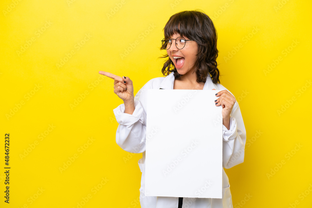 Young doctor latin woman isolated on yellow background holding an empty placard and pointing side Young doctor latin woman isolated on yellow background holding an empty placard and pointing side