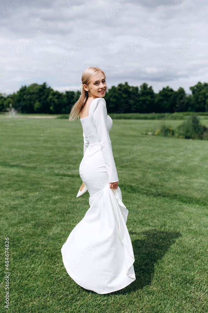 The bride runs barefoot on a green meadow. Summer day. The bride runs barefoot on a green meadow. Summer day.