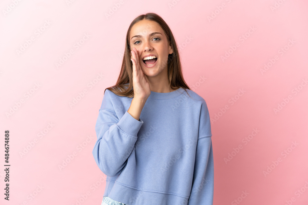Young woman over isolated pink background shouting with mouth wide open Young woman over isolated pink background shouting with mouth wide open