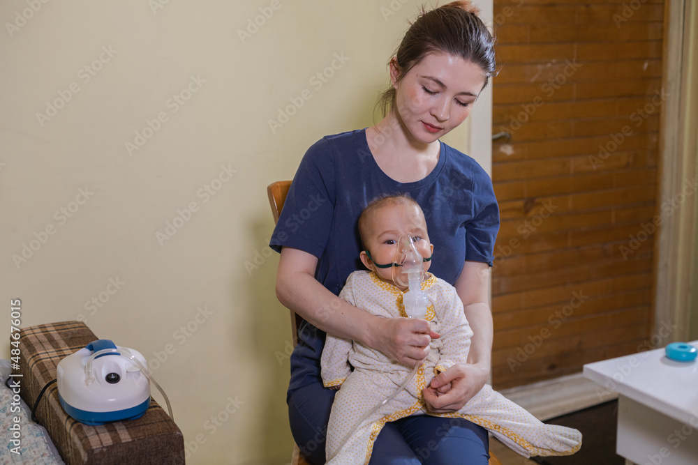 Baby inhaling fumes spray of the medication from a nebulizer Stock