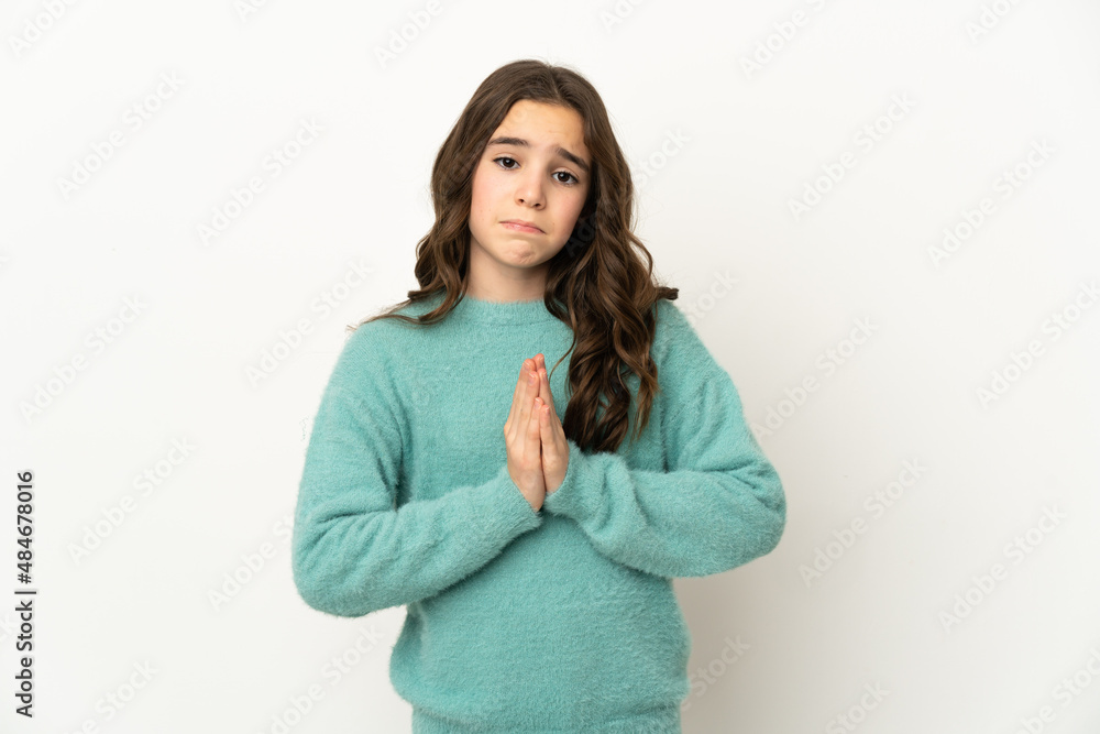 Little caucasian girl isolated on white background keeps palm together. Person asks for something Little caucasian girl isolated on white background keeps palm together. Person asks for something