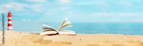 Buch am Strand mit Meer im Hintergrund