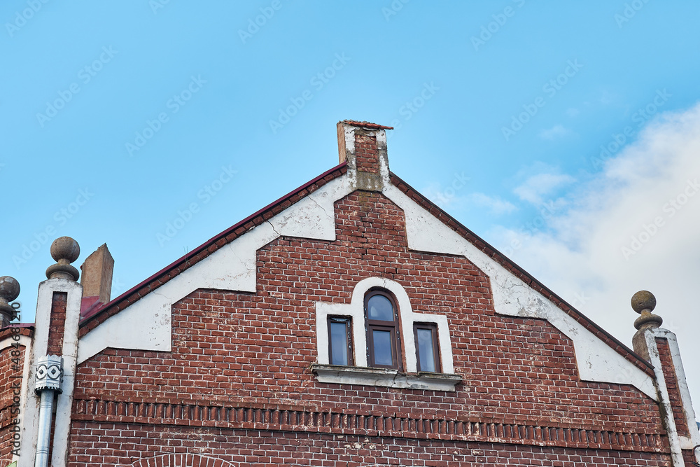 Facade of an old brick building with small windows.