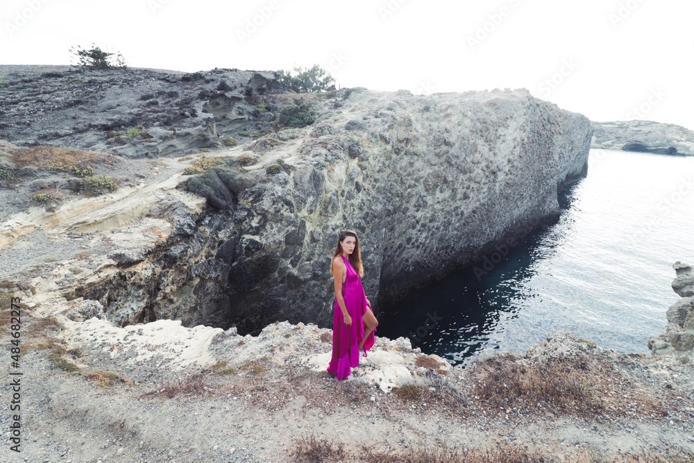 woman in a pink dress on a beach in milos greece