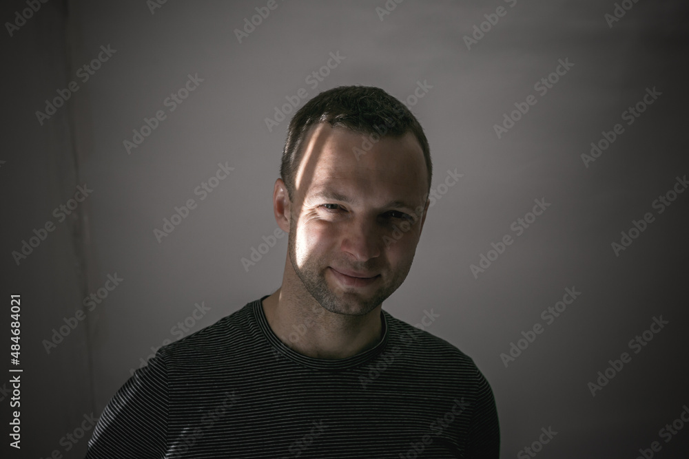 Portrait of young smiling man standing in shadow Portrait of young smiling man standing in shadow