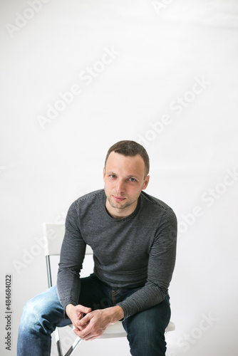 European man sitting on a white office chair © evannovostro