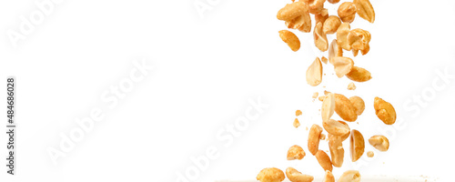 Peanut kernels falling with white background and copy space.
