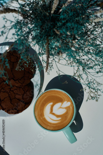 Obraz na płótnie Morning cappuccino in coffee shop on summer terrace with flowers and chocolate cookies. w salonie