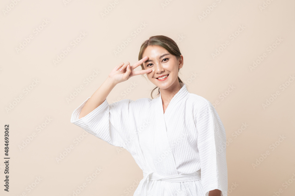 Portrait Beautiful young Asian women happy smile with perfect skin in bathrobe or spa suit on brown isolated studio background. Portrait Beautiful young Asian women happy smile with perfect skin in bathrobe or spa suit on brown isolated studio background.