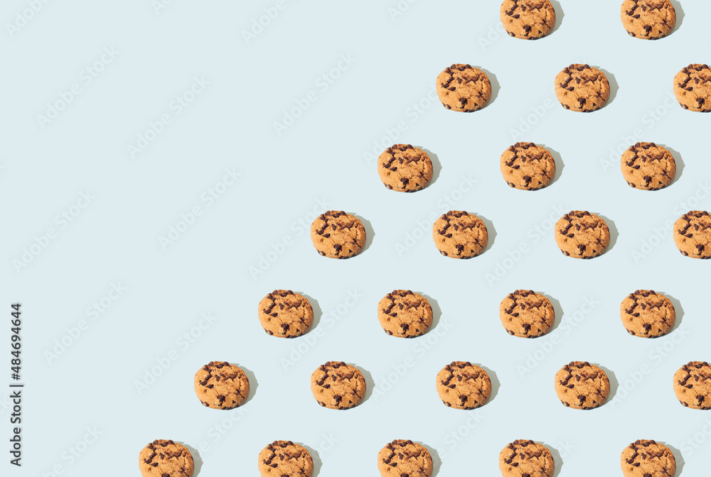Chocolate chips cookies on a blue background arranged in a pattern. Sweet food biscuit concept. Chocolate chips cookies on a blue background arranged in a pattern. Sweet food biscuit concept.