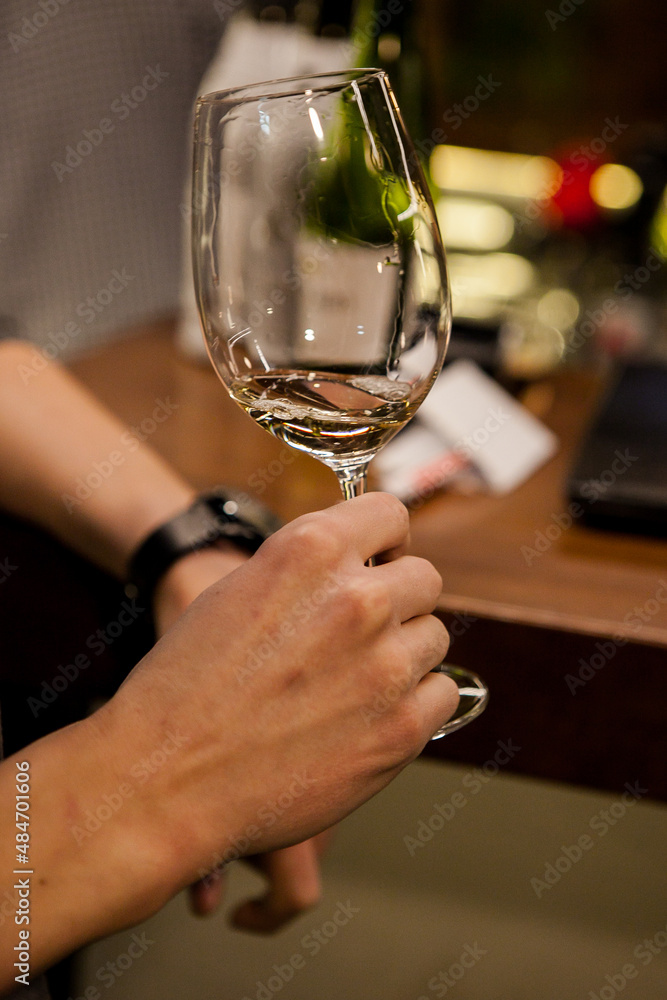 wine glass in the male sommelier's hand. Wine bar or winery. degustation. wine glass in the male sommelier's hand. Wine bar or winery. degustation.