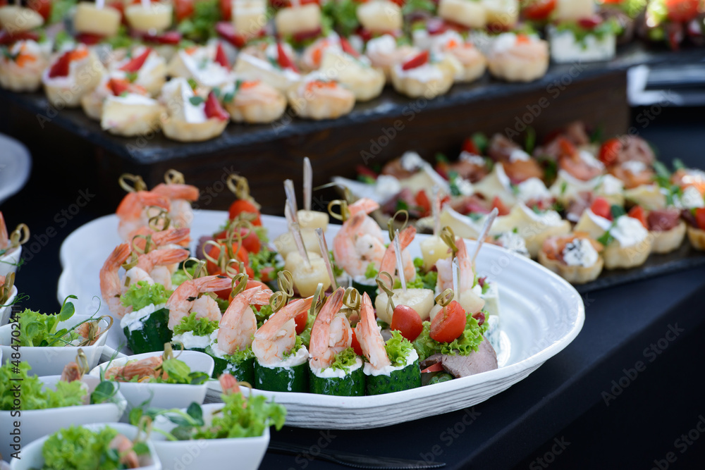 appetizer of cucumber with shrimp and cream cheese on a skewer closeup on a white plate. horizontal appetizer of cucumber with shrimp and cream cheese on a skewer closeup on a white plate. horizontal